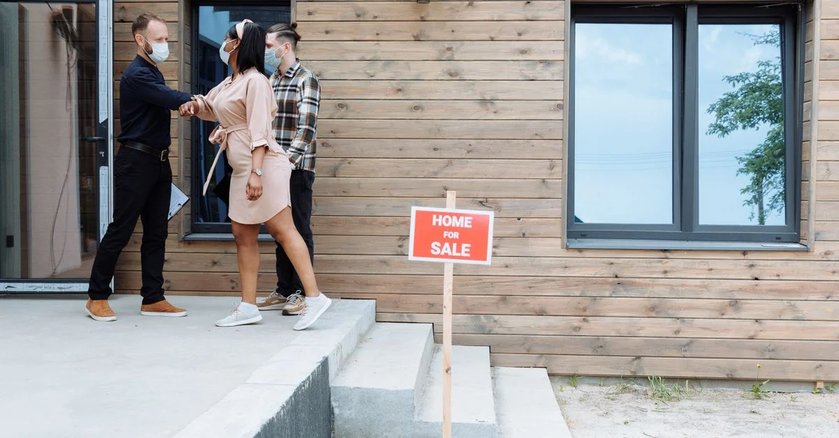 Couple rencontrant un agent immobilier pour la vente d'une maison, portant des masques pour la sécurité.