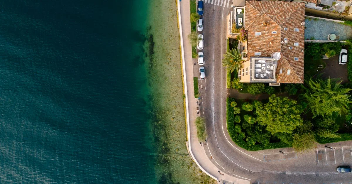 Vue par drone de la côte avec une route et des bâtiments au bord de l'océan.