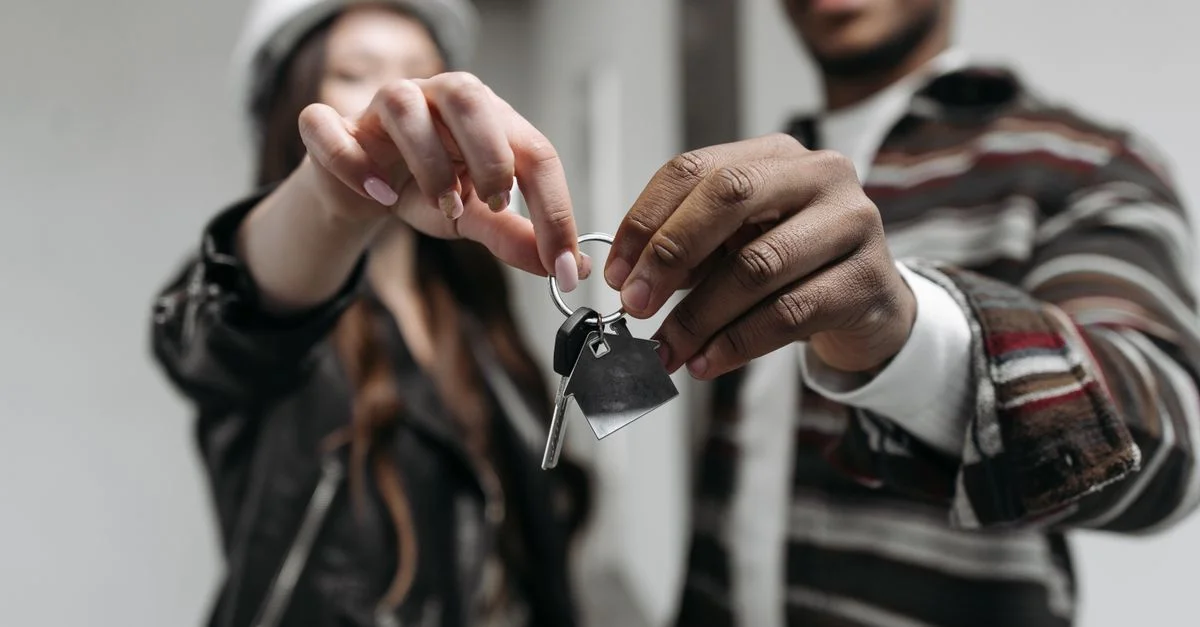 Gros plan d'un couple tenant joyeusement les clés de leur nouvelle maison, symbolisant les nouveaux départs et la propriété.